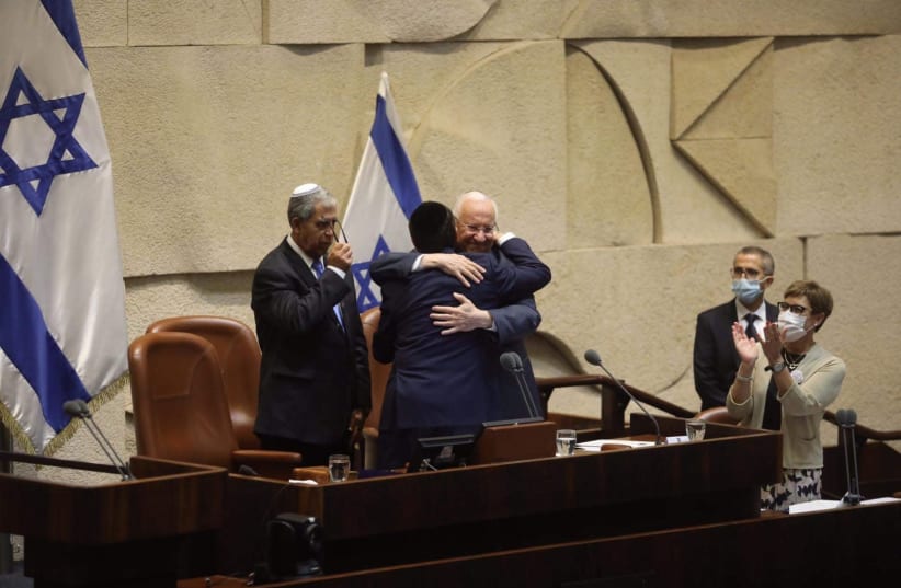 Outgoing President Reuven Rivlin hugs incoming President Isaac Herzog during Herzog's inauguration, July 7, 2021. (photo credit: MARC ISRAEL SELLEM)