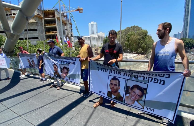 Protestors outside Tel Aviv Hashalom train station demand the return of Hadar Goldin and Oron Shaul, July 8, 2021. (photo credit: AVSHALOM SASSONI/ MAARIV)