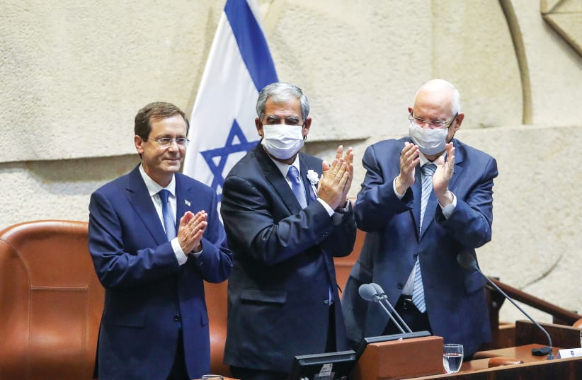 PRESIDENT ISAAC Herzog addresses the Knesset on Wednesday as Knesset Speaker Mickey Levy and Herzog’s predecessor, Reuven Rivlin, applaud. (photo credit: MARC ISRAEL SELLEM/THE JERUSALEM POST)