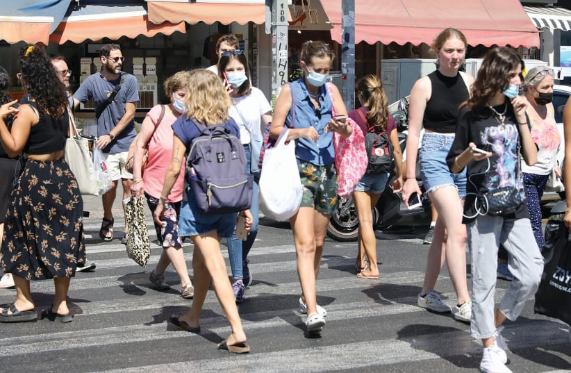 A TEL AVIV crosswalk this week, with a mix of masked and unmasked pedestrians. (photo credit: MARC ISRAEL SELLEM/THE JERUSALEM POST)