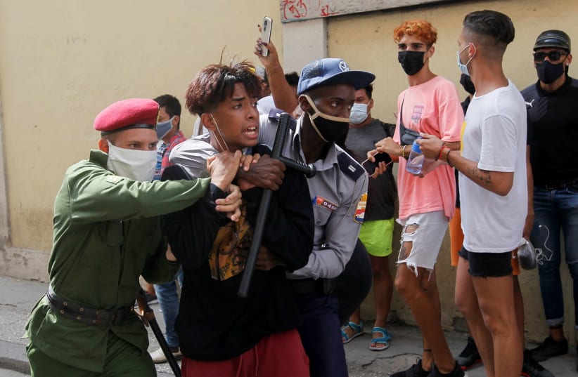 Police detain a person during protests against and in support of the government, amidst the coronavirus disease (COVID-19) outbreak, in Havana, Cuba July 11, 2021 (photo credit: REUTERS/STRINGER)