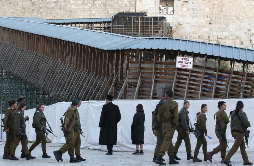 Israeli soldiers walking past Mughrabi Bridge, the wooden footbridge leading up from the Western Wall to the sacred compound where al-Aqsa mosque and the Dome of the Rock shrine (not seen), in Jerusalem's Old City. (photo credit: NATI SHOHAT/FLASH90)