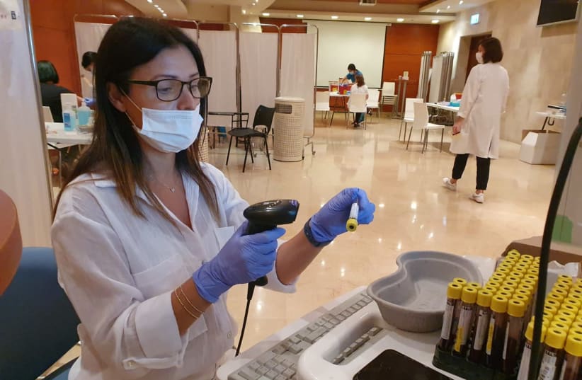 Medical personnel is seen examining blood samples at Rambam Health Care Campus in Haifa, Israel. (photo credit: RAMBAM HEALTHCARE CAMPUS)