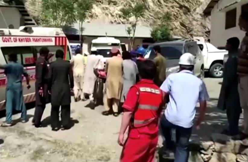 People wheel a gurney towards an ambulance outside a hospital in Dasu, after a bus with Chinese nationals on board plunged into a ravine in Upper Kohistan following a blast, Pakistan July 14, 2021 in this still image taken from video.  (photo credit: REUTERS TV)