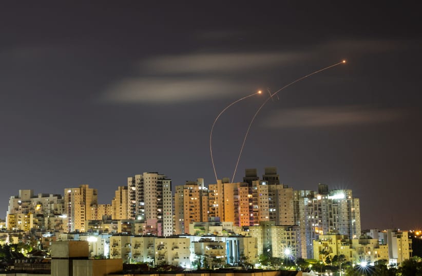 Streaks of light are seen from Ashkelon as the Iron Dome anti-missile system intercepts rockets launched from the Gaza Strip on May 20, 2021. (photo credit: AMIR COHEN/REUTERS)