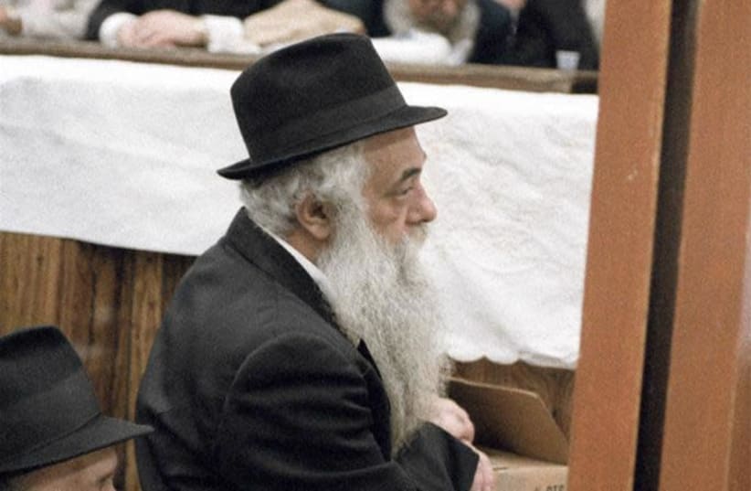 Rabbi Yoel HaKohen Kahn, known simply as Reb Yoel, was chief scribe of the Rebbe, Rabbi Menachem M. Schneerson, of righteous memory, for over 40 years. Seen here in a familiar pose listening to the Rebbe teach at the farbrengen gathering of 12 Tammuz 1983. (photo credit: JEWISH EDUCATIONAL MEDIA/THE LIVING ARCHIVE)