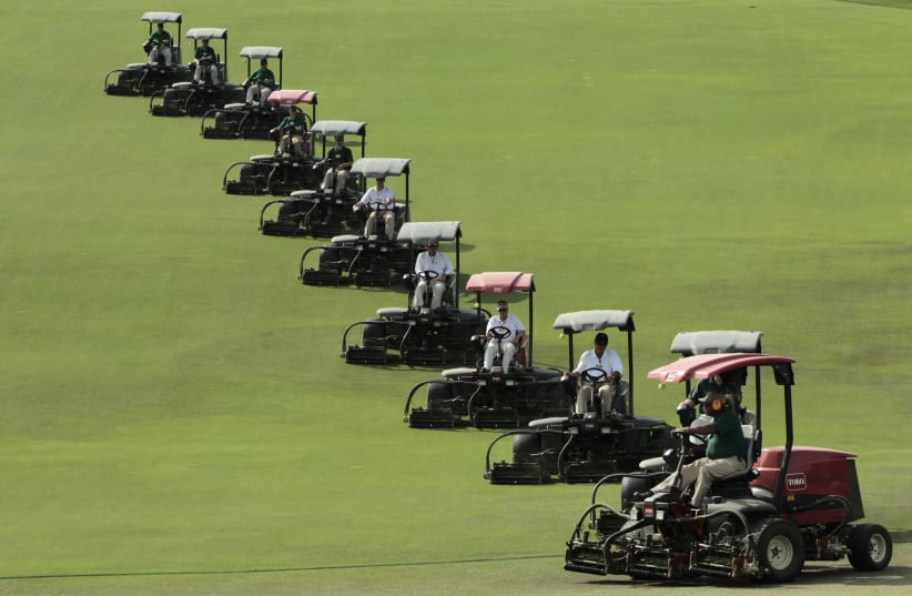 Lawn mowers in formation prepare the course for first round play in the 2010 Masters golf tournament at the Augusta National Golf Club in Augusta (photo credit: HANS DERYK/REUTERS)