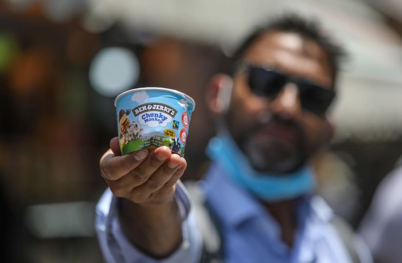 A man holds a small cup of Ben & Jerry's ice cream, Jerusalem (photo credit: MARC ISRAEL SELLEM)