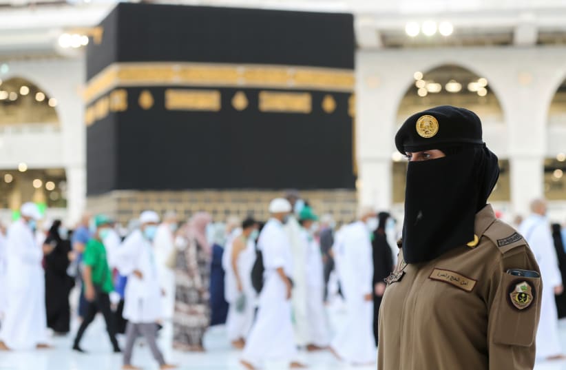 A female Saudi police officer stands guard as pilgrims perform Tawaf during Hajj/Mecca, Saudi Arabia. (photo credit: REUTERS/AHMED YOSRI)