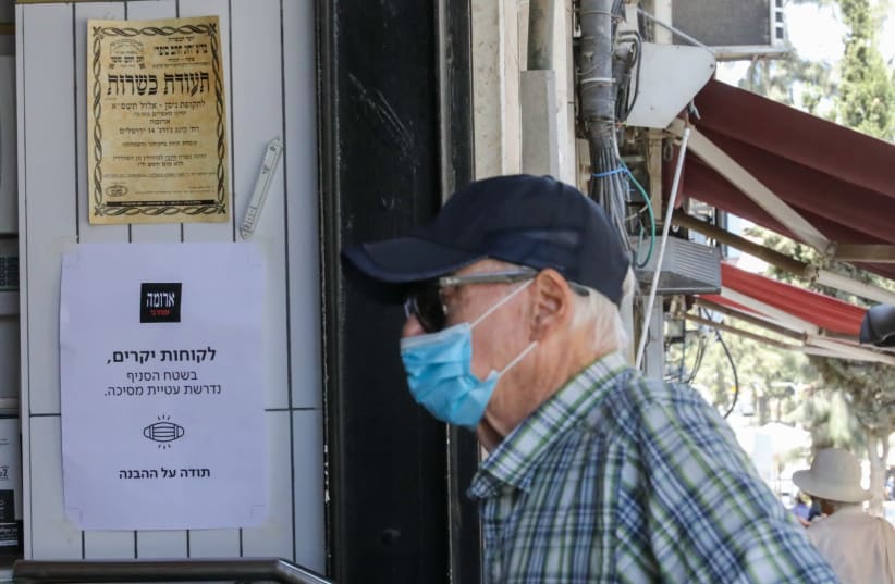 Man walks into Aroma wearing a mask (photo credit: MARC ISRAEL SELLEM)