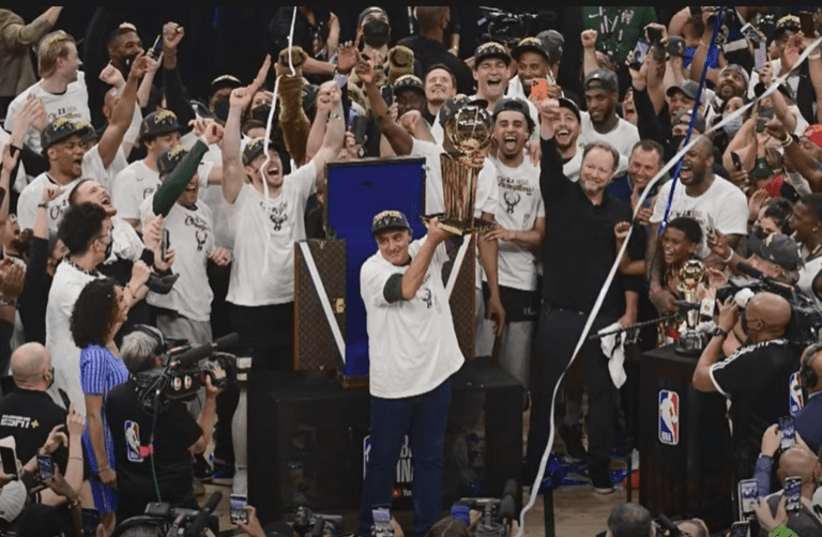 Jewish-American businessman Marc Lasry holds the NBA trophy after Milwaukee Bucks win NBA championship, July 20, 2021. (photo credit: YOUTUBE SCREENSHOT)