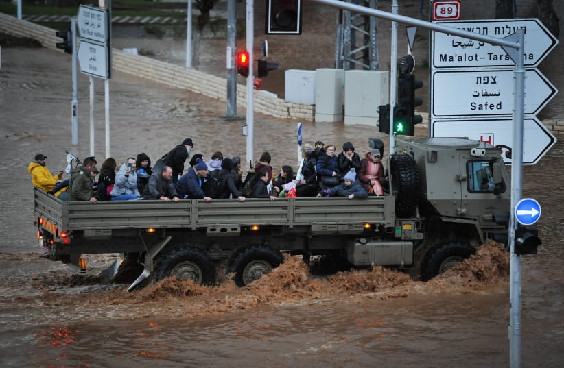 A military truck evacuates Israeli citizens through a flooded road in the northern Israeli city of Nahariya, on a stormy winter day, on January 8, 2020. (photo credit: MEIR VAKNIN/FLASH90)