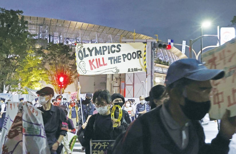 DEMONSTRATORS PROTEST in May near Tokyo’s Olympic Stadium against holding the 2020 Olympics amid the coronavirus pandemic. (photo credit: KYODO/VIA REUTERS)