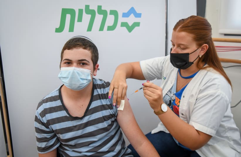 A YOUTH receives the COVID-19 vaccine at a Clalit inoculation center in Petah Tikva last week. (photo credit: FLASH90)