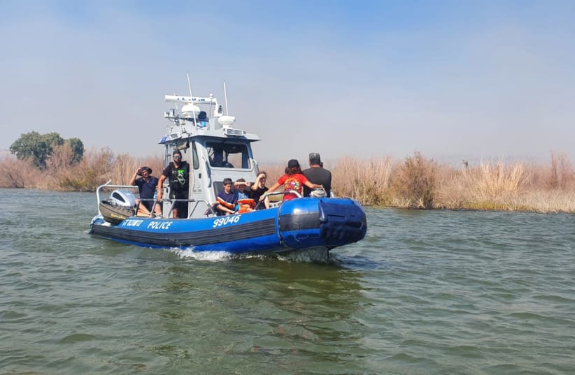 Bathers evacuated by a police boat due to a fire just north of the Kinneret, July 27th 2021. (photo credit: ISRAEL POLICE SPOKESMAN)