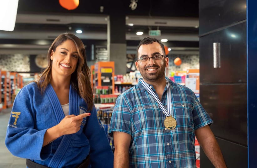 Former Olympian medal winner Judoka Yarden Gerbi awards a medal to buyers of blue and white products in a new campaign (photo credit: Courtesy)