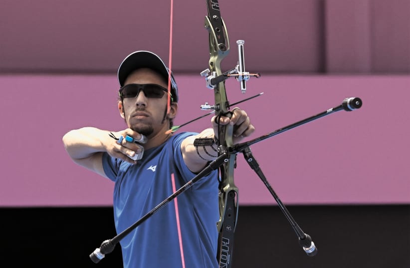 Israeli Archer Itay Shanny competes yesterday at the Tokyo Olympics, where he shot his way to two big victories to qualify for the Saturday’s round-of-16. (photo credit: CLODAGH KILCOYNE/ REUTERS)