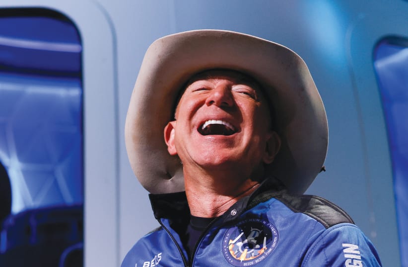 BILLIONAIRE AMERICAN businessman Jeff Bezos reacts at a post-launch press conference in western Texas earlier this month after his flight to the edge of space. (photo credit: JOE SKIPPER/REUTERS)