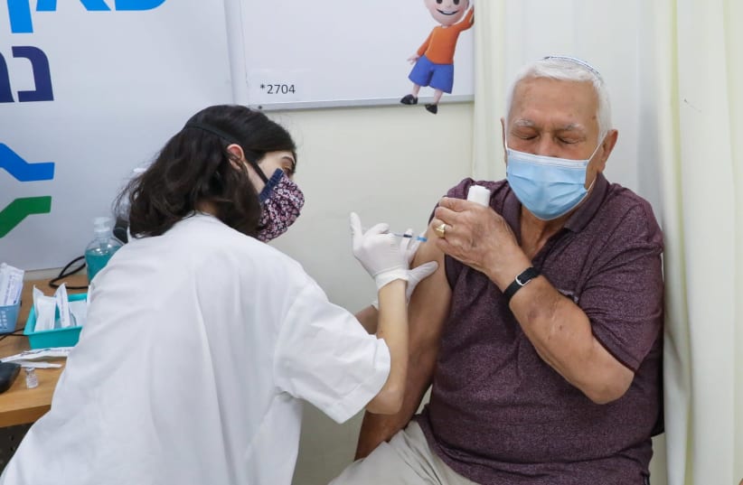 An elderly Israeli is seen receiving the third COVID-19 booster shot at a Clalit clinic in Jerusalem, on August 1, 2021. (photo credit: MARC ISRAEL SELLEM/THE JERUSALEM POST)