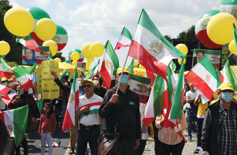 SUPPORTERS OF the National Council of Resistance of Iran gather to protest against the government in Tehran, in front of the Brandenburg Gate in Berlin, last month.  (photo credit: CHRISTIAN MANG / REUTERS)