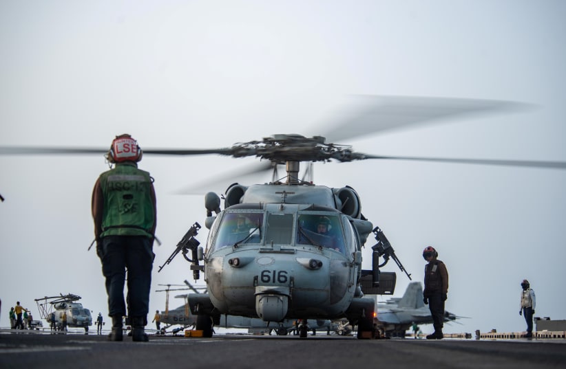  Sailors prepare an MH-60S Sea Hawk helicopter, attached to the “Golden Falcons” of Helicopter Sea Combat Squadron (HSC) 12, to launch on the flight deck of aircraft carrier USS Ronald Reagan (CVN 76), in response to a call for assistance from the Mercer Street, a Japanese-owned Liberian-flagged tan (photo credit: US NAVY/HANDOUT VIA REUTERS)