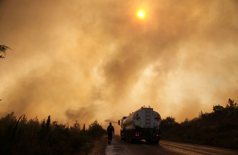 Firefighters extinguish a wildfire in the Mazi region near Bodrum, Turkey, August 2, 2021.  (photo credit: REUTERS/KENAN GURBUZ)