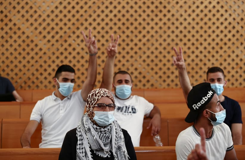  A supporter of the El-Kurd family, Palestinian residents of Sheikh Jarrah neighborhood in east Jerusalem who are facing eviction, looks on as family members flash victory signs during a court hearing, in the Israeli Supreme Court, in Jerusalem August 2, 2021. (photo credit: REUTERS/Ronen Zvulun)