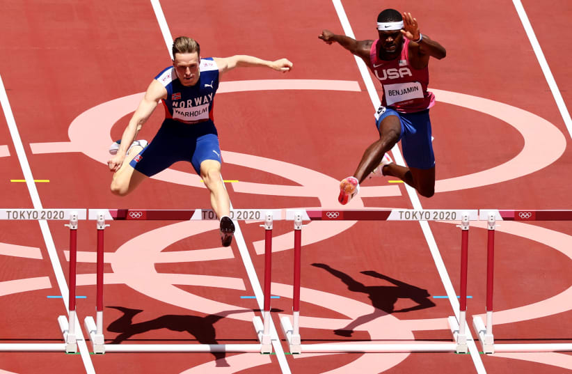 Norway's Karsten Warholm on his way to victory with American Rai Benjamin in pursuit at the men's 400m hurdles final. August 3rd, 2021. (photo credit: ANDREW BOYERS/REUTERS)