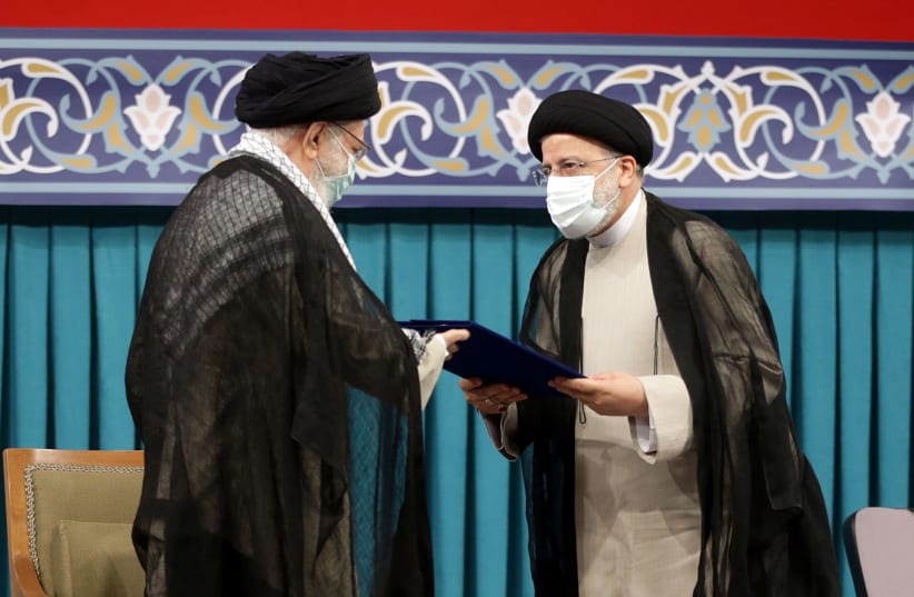  Iran's new President Ebrahim Raisi receives the endorsement decree for his presidency from Iran's Supreme Leader Ayatollah Ali Khamenei, in Tehran, Iran August 3, 2021. (photo credit: OFFICIAL KHAMENEI WEBSITE/HANDOUT VIA REUTERS)