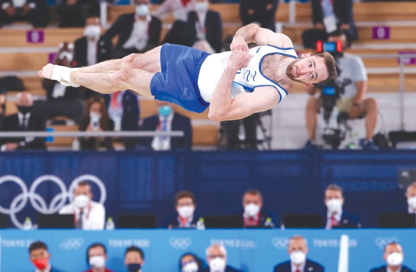  ARTEM DOLGOPYAT soars through the air in Tokyo to an historic gold medal for Israel. (photo credit: LINDSEY WASSON/REUTERS)