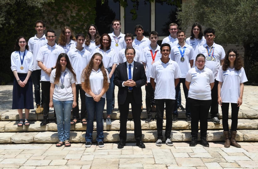 Israel's President Isaac Herzog is seen congratulating the high school students who won at the international science Olympics, on August 8, 2021. (photo credit: MARK NEYMAN/GPO)