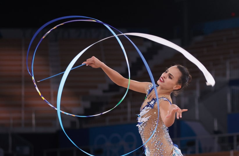 ISRAEL'S LINOY ASHRAM performs in the ribbon component of the women's all-around rhythmic gymnastics finals competition on Saturday. The 22-year-old Israeli captured the gold medal, the first blue-and-white female Olympian to stand atop the podium. (photo credit: REUTERS)
