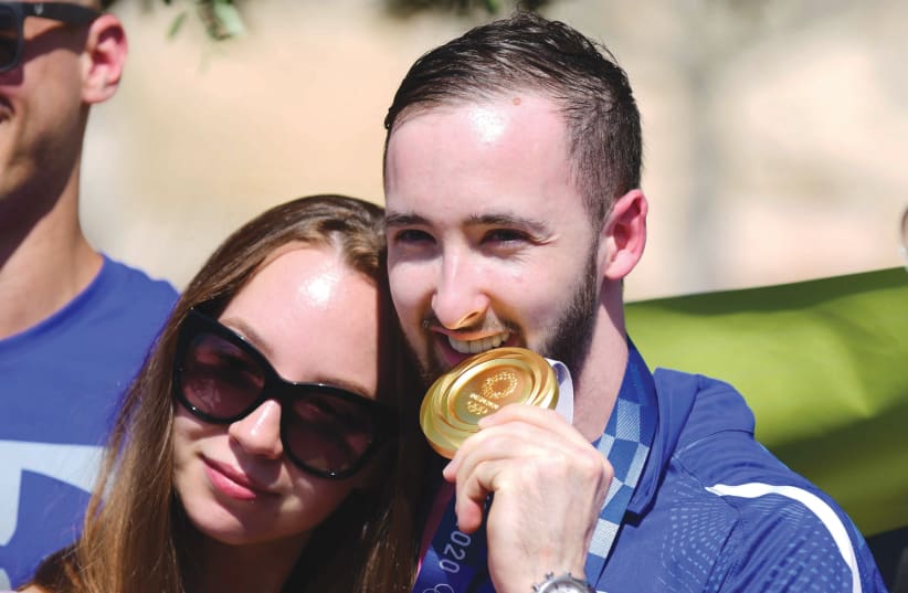 ARTEM DOLGOPYAT, who won the gold medal in the Olympic Games in Tokyo, with his girlfriend during a welcome ceremony at Ben-Gurion Airport last week. (photo credit: TOMER NEUBERG/FLASH90)