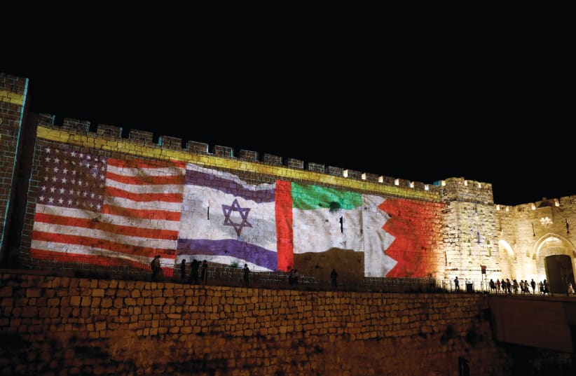  THE FLAGS of the US, Israel, UAE and Bahrain are projected on a section of the walls surrounding Jerusalem’s Old City last September. (photo credit: RONEN ZVULUN/REUTERS)