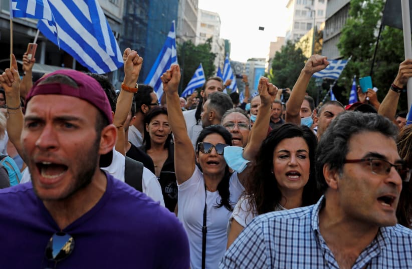  Anti-vaccine demonstrators shut slogans during a protest in Athens last month (photo credit: COSTAS BALTAS / REUTERS)