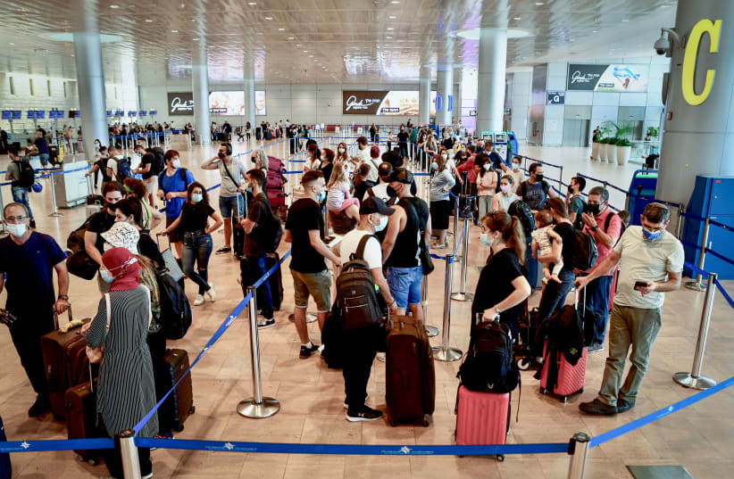  Travellers wear protective face masks at Terminal 3, Ben Gurion International Airport, as Israel restricts air travel more, on August 05, 2021.  (photo credit: AVSHALOM SASSONI/FLASH90)