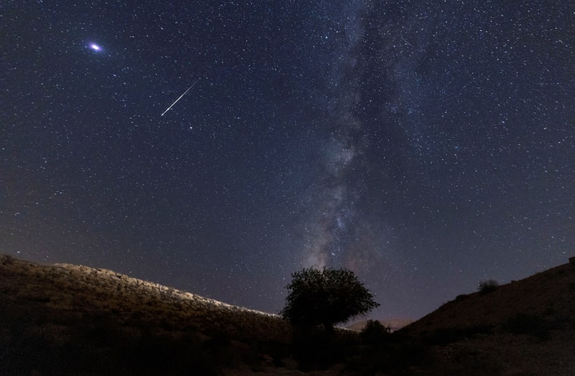  A meteor streaks past stars in the night sky during the annual Perseid meteor shower at the Negev Desert in southern Israel, August 13, 2021. (photo credit: REUTERS/AMIR COHEN)