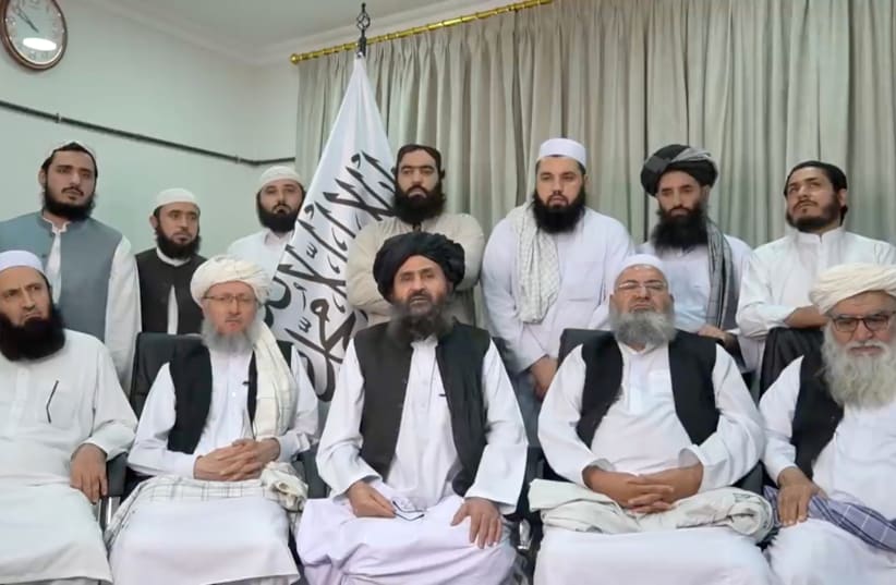  Mullah Baradar Akhund, a senior official of the Taliban, seated with a group of men, makes a video statement, in this still image taken from a video recorded in an unidentified location and released on August 16, 2021 (photo credit: SOCIAL MEDIA/REUTERS)