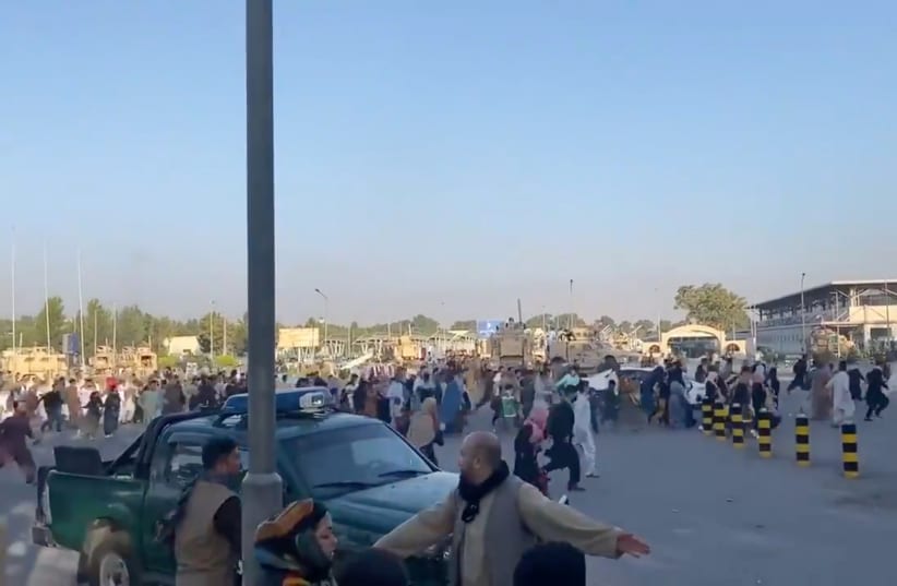  A horde of people run towards the Kabul Airport Terminal, after Taliban insurgents took control of the presidential palace in Kabul, August 16, 2021, in this still image taken from video obtained from social media (photo credit: Jawad Sukhanyar)