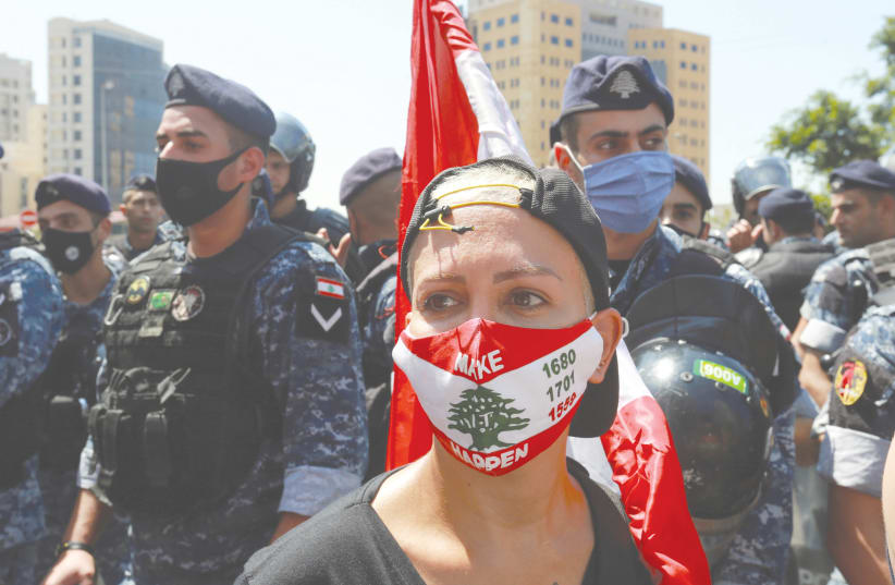  A woman wears a face mask during a protest called by the families of the victims of last year's Beirut port blast, near UNESCO Palace in Beirut, Lebanon, earlier this month.  (photo credit: AZIZ TAHER/REUTERS)