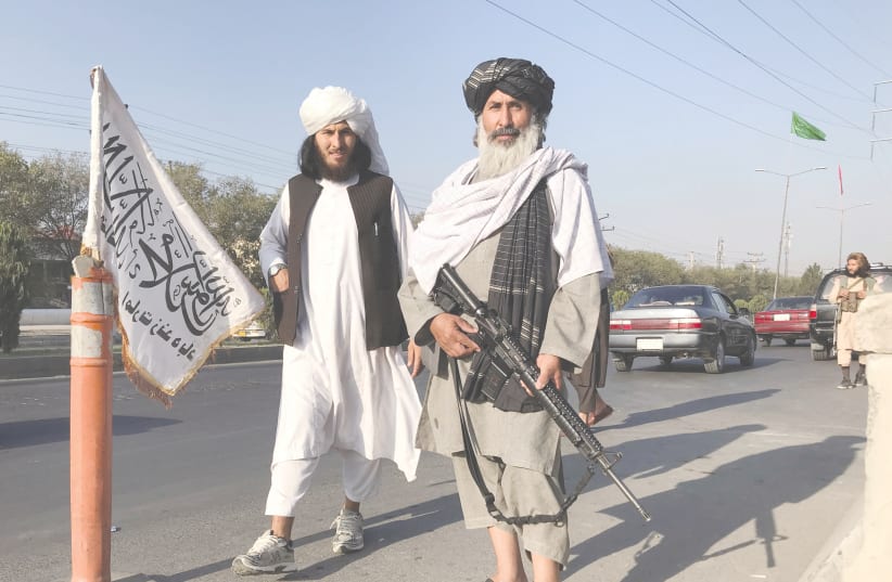  TALIBAN FIGHTERS stand outside the Interior Ministry in Kabul yesterday.  (photo credit: REUTERS)