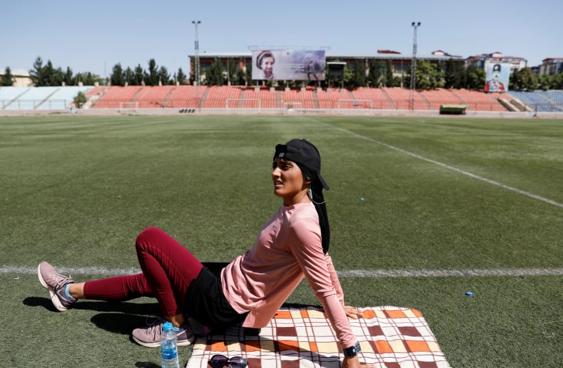  Afghan sprinter Kimia Yousofi, 25, sits down during training ahead of the 2020 Summer Olympics in Tokyo, at a stadium in Kabul, Afghanistan July 1, 2021 (photo credit: REUTERS/MOHAMMAD ISMAIL)