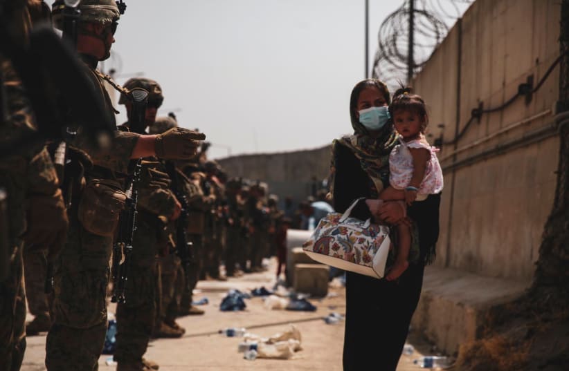  Marines with the 24th Expeditionary Unit (MEU) guide an evacuee during an evacuation at Hamid Karzai International Airport, Kabul, Afghanistan, in this photo taken on August 18, 2021 (photo credit: US NAVY/CENTRAL COMMAND PUBLIC AFFAIRS/SGT. ISAIAH COMPBELL/HANDOUT VIA REUTERS)