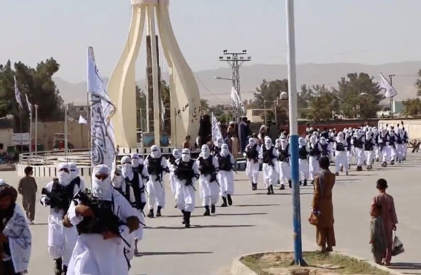  Taliban fighters march in uniforms on the street in Qalat, Zabul Province, Afghanistan, in this still image taken from social media video uploaded August 19, 2021  (photo credit: REUTERS)
