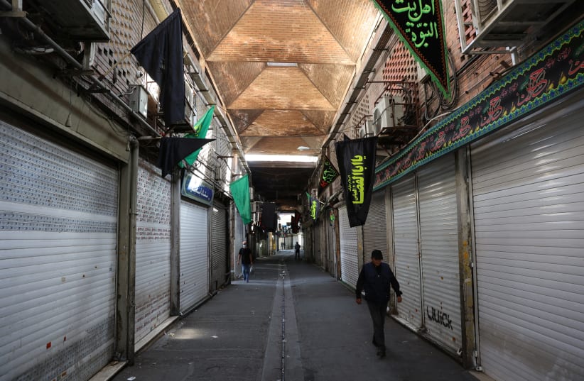  A man walks next to closed shops of Tehran Bazaar following the tightening of restrictions to curb the surge of the coronavirus disease (COVID-19) cases, in Tehran, Iran August 16, 2021 (photo credit: MAJID ASGARIPOUR/WANA)