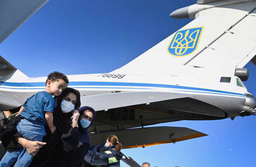  People evacuated from Afghanistan disembark from a plane at Boryspil International Airport outside Kyiv, Ukraine (photo credit: Ukrainian Presidential Press Service/Handout via REUTERS)
