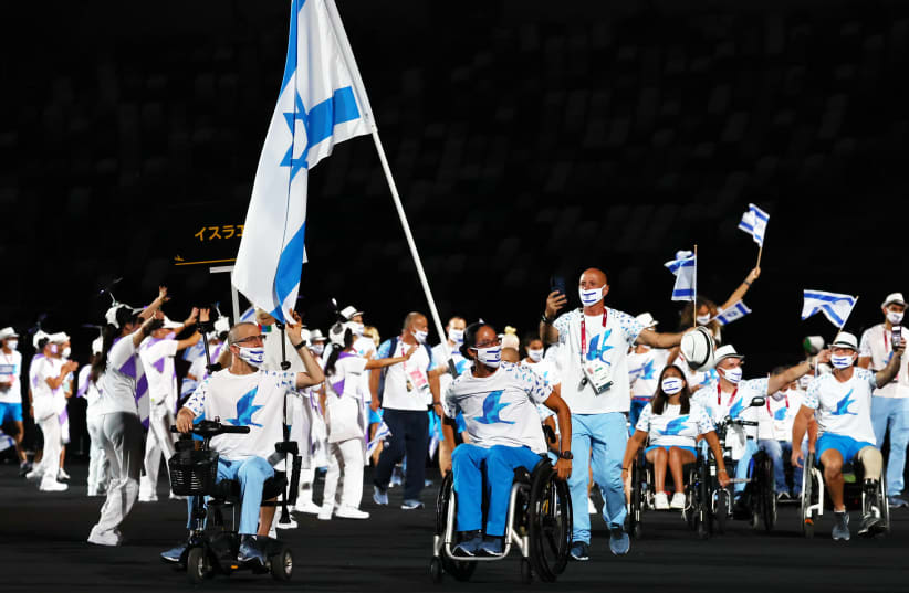  Tokyo 2020 Paralympic Games - The Tokyo 2020 Paralympic Games Opening Ceremony - Olympic Stadium, Tokyo, Japan - August 24, 2021. Moran Samuel of Israel and Nadav Levi of Israel lead their contingent during the athletes parade at the opening ceremony. (photo credit: REUTERS/ATHIT PERAWONGMETHA)