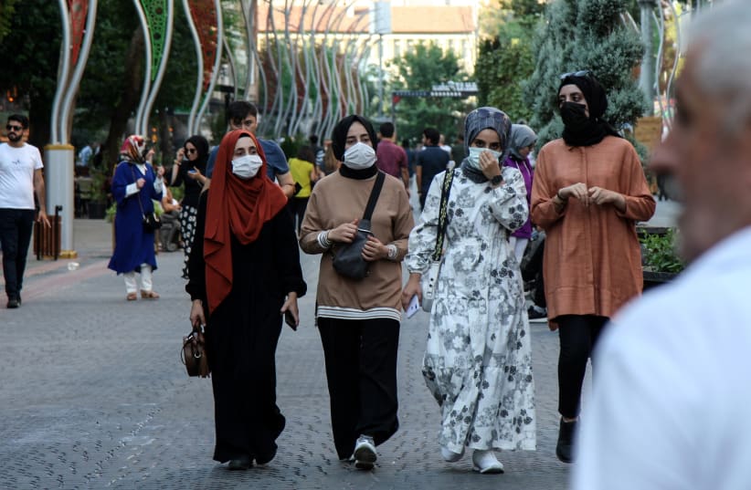  People wearing protective masks walk along a street amid a surge in COVID-19 cases in Diyarbakir, Turkey (photo credit: SERTAC KAYAR / REUTERS)