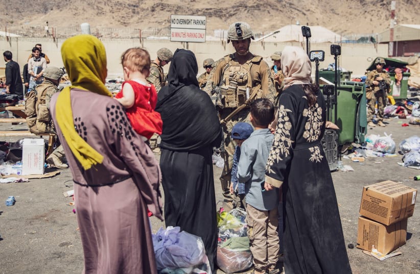  US Marines with the 24th Marine Expeditionary Unit (MEU) process evacuees as they go through the Evacuation Control Center (ECC) during an evacuation at Hamid Karzai International Airport, Kabul, Afghanistan, August 28, 2021.  (photo credit: SGT. VICTOR MANCILLA/US MARINE CORPS/HANDOUT VIA REUTERS)