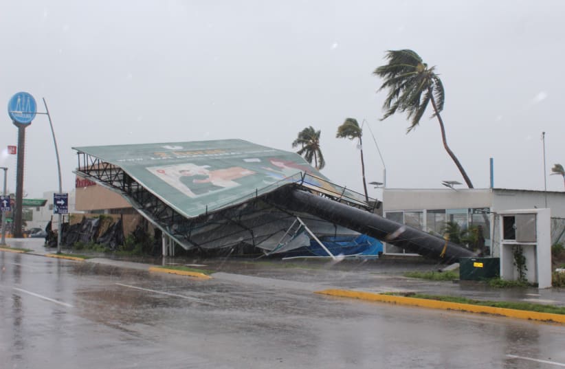  An advertising structure felled by wind is pictured in a street as Hurricane Nora barrels towards southwest coast of Mexico, in Manzanillo, in Colima state, Mexico August 28, 2021. (photo credit: REUTERS/JESUS LOZOYA)